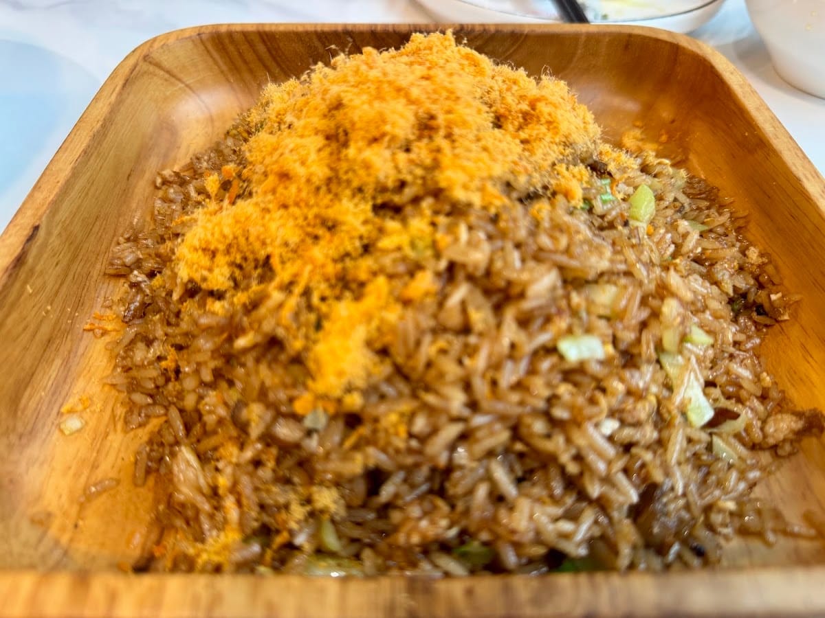 Fried rice heaped with meat floss in a square wooden tray